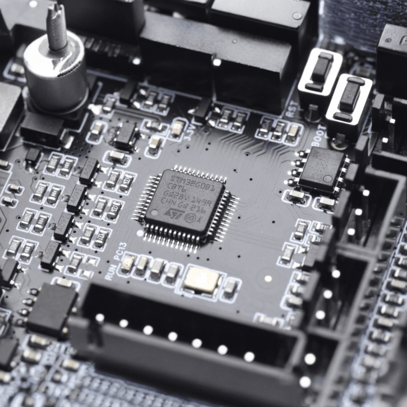 Close-up of a circuit board featuring an STM32G0B1 microcontroller chip surrounded by surface-mount components and connectors